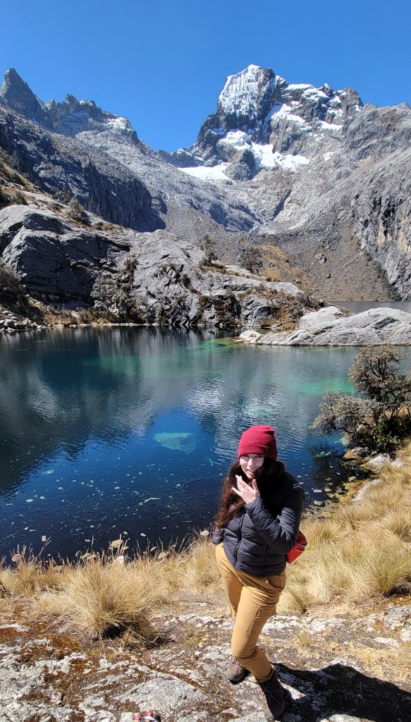 Hiker by an alpine lake in the mountains
